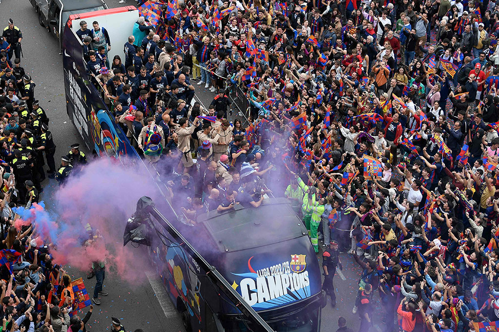 Para pemain naik dua bus beratap terbuka, dari Camp Nou ke monumen kota Arc de Triomf yang berjarak lima mil, sementara jalan-jalan dipenuhi ribuan pendukung.
