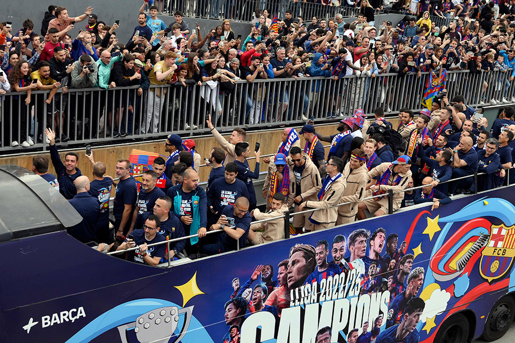 Di depan bus kedua pemain, bus lain yang mengeluarkan lagu-lagu pop untuk mengatur suasana memimpin, menerobos jalan-jalan yang dipenuhi asap biru dan merah.