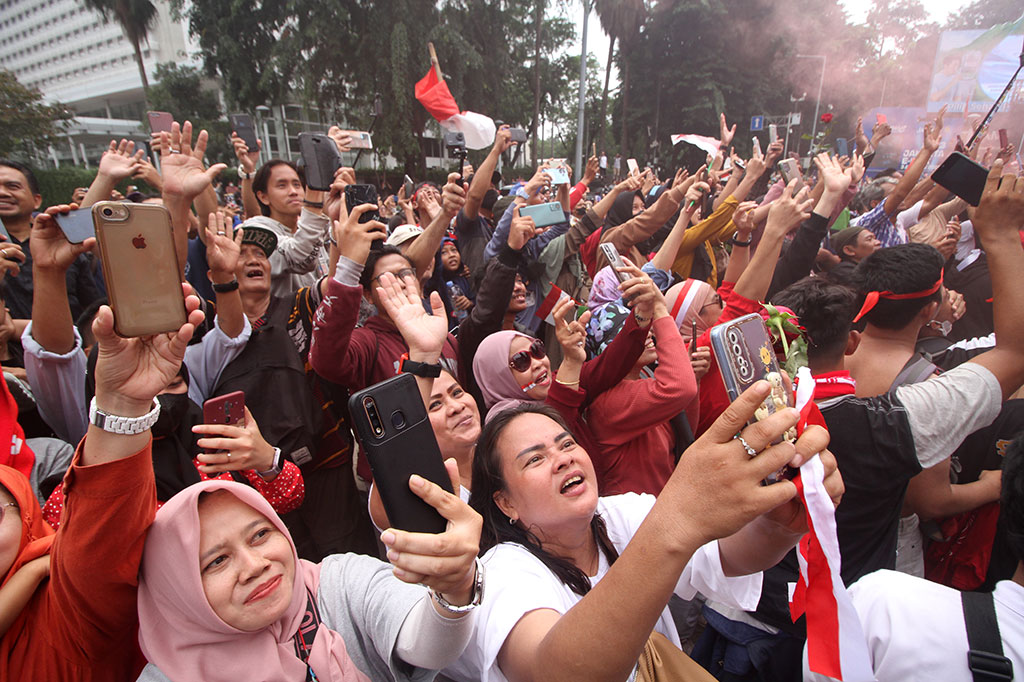 Sambil mengibarkan bendera Merah Putih, mereka berteriak-teriak 