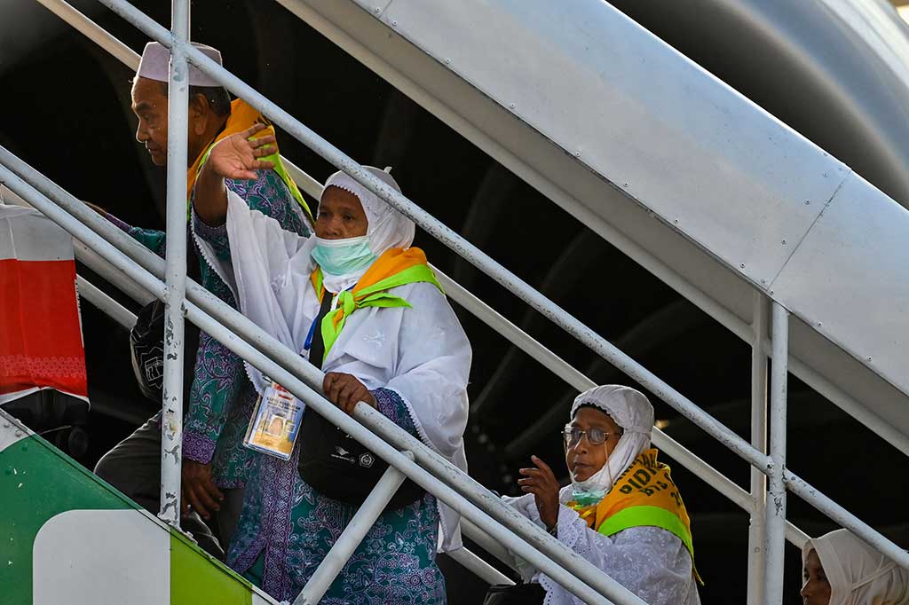 Calon haji kloter pertama embarkasi Aceh melambaikan tangan saat menaiki tangga pesawat Garuda Indonesia yang akan membawa jemaah menuju Madinah, Arab Saudi di Bandara Internasional Sultan Iskandar Muda, Aceh Besar, Aceh, Rabu, 24 Mei 2023. 