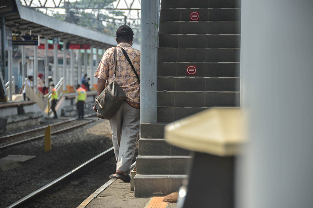 Warga berjalan di samping tangga peron 3 dan 4, yang sangat sempit di Stasiun Serpong, Tangerang Selatan, Banten, Kamis, 25 Mei 2023.