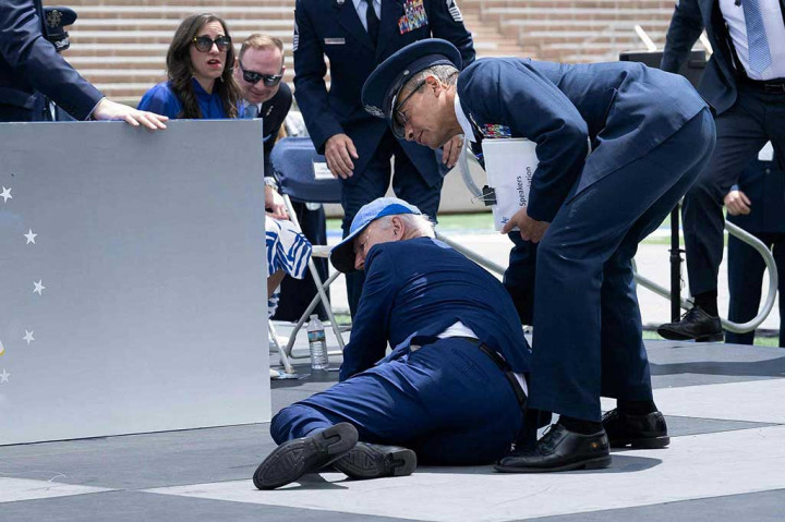 Biden tersandung karung pasir saat membagikan ijazah pada upacara kelulusan Akademi Angkatan Udara AS.