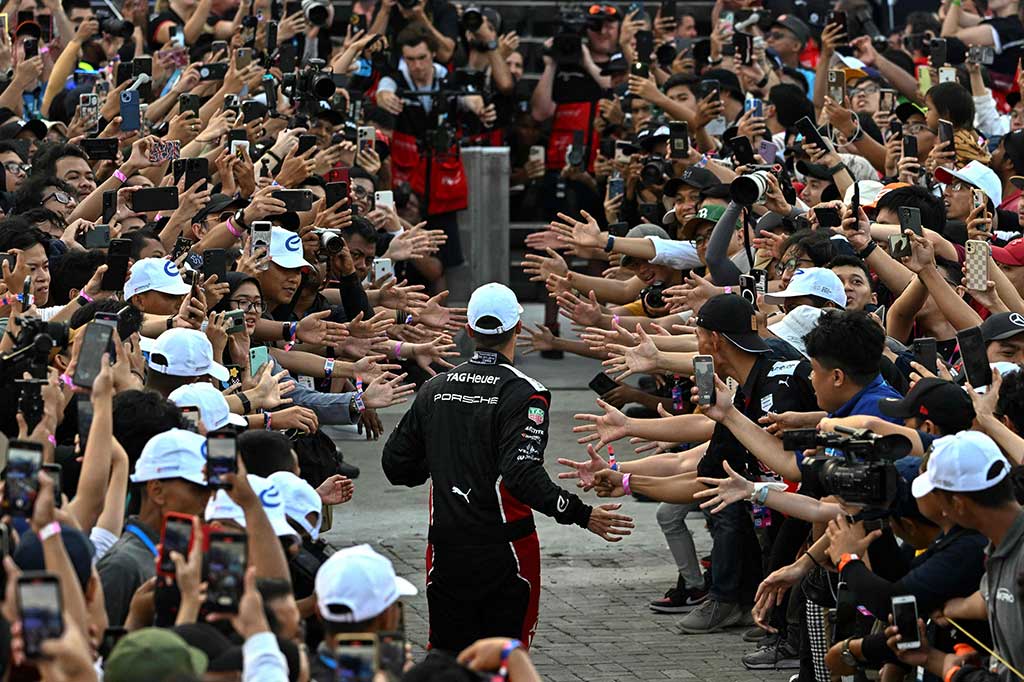 Pembalap Formula E Tag Heuer Porsche asal Jerman Pascal Wehrlein (tengah) menyapa para penggemarnya usai menjuarai balapan Formula E seri ke-10 di Sirkuit Internasional e-Prix Ancol, Jakarta, Sabtu, 3 Juni 2023.