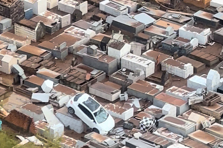 Seorang bayi berusia empat bulan termasuk di antara korban tewas, menurut media lokal, yang menyiarkan rekaman sebuah mobil yang tersapu ke kuburan oleh angin kencang.