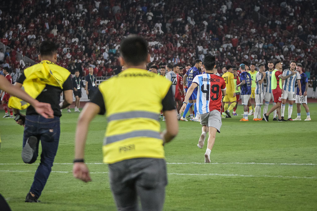Aksi pria yang berlari ke arah kumpulan pemain Argentina tersebut sontak membuat para steward mengejarnya.