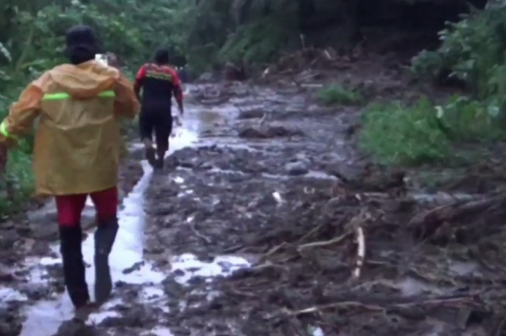Warga terpaksa melintas dengan berjalan kaki lantaran akses jalan tertutup material longsor. Warga berharap pemerintah segera turun tangan agar akses tersebut bisa dilalui untuk mobilitas warga. 