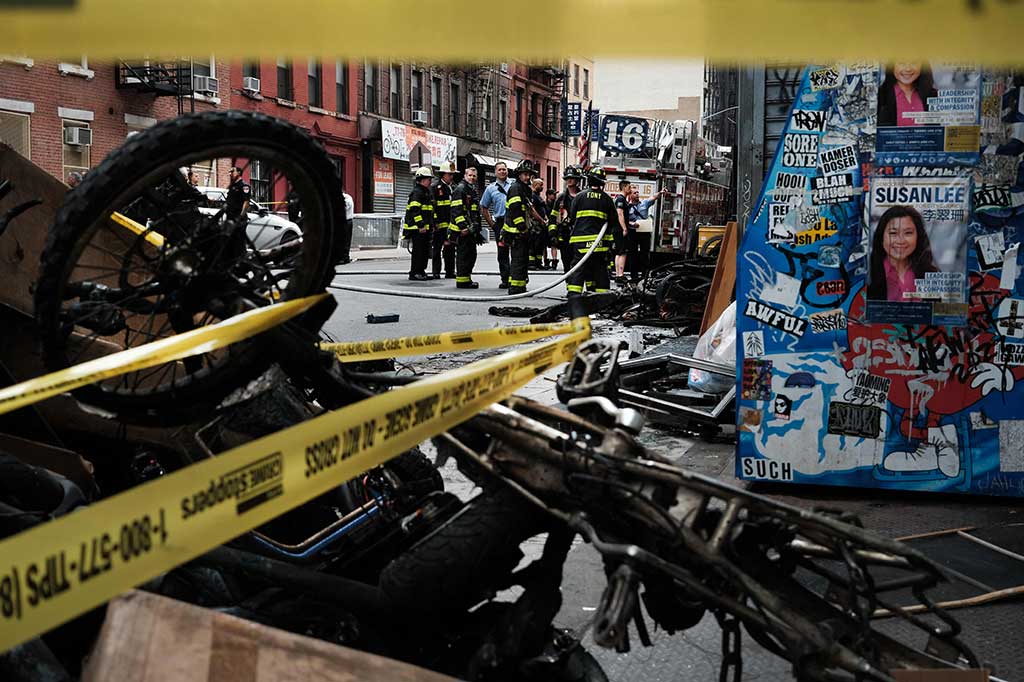 Petugas pemadam kebakaran bekerja di luar gedung di Chinatown setelah empat orang tewas akibat kebakaran di bengkel e-bike di New York City, Selasa, 20 Juni 2023 waktu setempat.