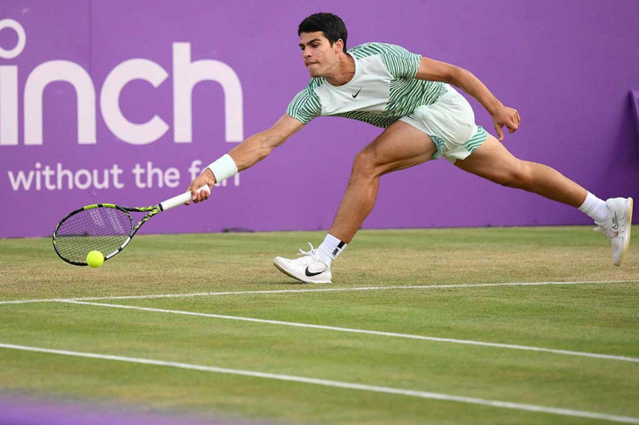 Petenis Spanyol Carlos Alcaraz mencoba mengembalikan bola ke arah petenis Bulgaria Grigir Dimitrov pada babak perempat final Cinch ATP di Queen's Club, London, Jumat, 23 Juni 2023 waktu setempat.