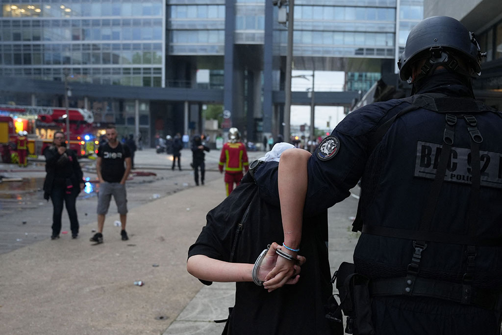 Petugas polisi dari brigade anti-kejahatan (BAC) menangkap seorang pengunjuk rasa selama bentrokan yang pecah setelah unjuk rasa memprotes penembakan terhadap seorang pengemudi remaja hingga tewas, di Nanterre, Paris, Kamis, 29 Juni 2023.