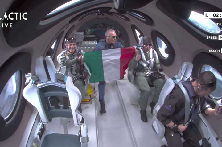 Perwira Angkatan Udara Italia mengibarkan bendera negaranya dan mengintip ke luar jendela ke lengkungan Bumi sambil menikmati beberapa menit tanpa bobot di ketinggian 52,9 mil (85,1 kilometer) di atas permukaan laut.