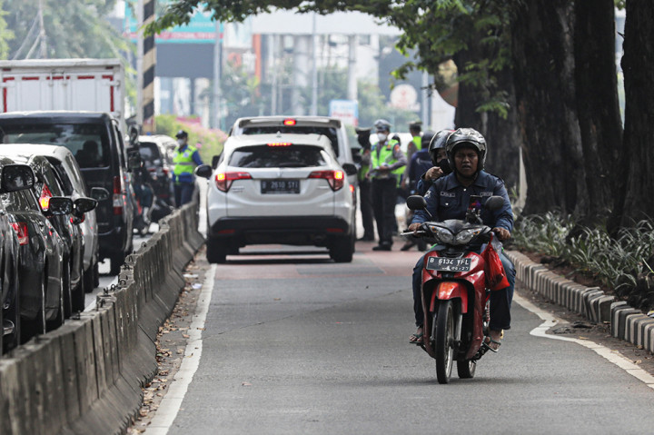 Pengendara sepeda motor nekat memutar balik melawan arah untuk menghindari razia polisi saat masik di jalur bus TransJakarta