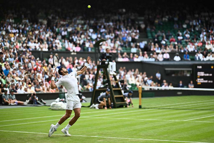 Novak Djokovic melancarkan servis ke arah Stan Wawrinka pada babak ketiga turnamen tenis Wimbledon, Wimbledon, London, Jumat, 7 Juli 2023.