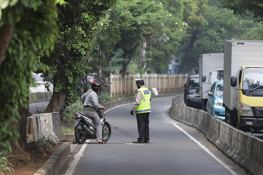 Petugas kepolisian melakukan sterilisasi jalur dan tindakan tilang terhadap pengendara sepeda motor yang masuk ke jalur Busway di kawasan Simpruk, Jakarta Selatan, Rabu, 12 Juli 2023. 