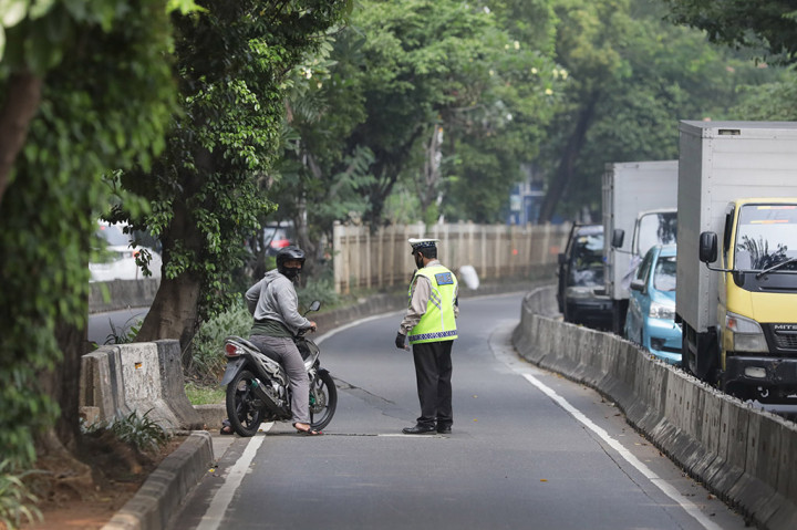 Petugas kepolisian melakukan sterilisasi jalur dan tindakan tilang terhadap pengendara sepeda motor yang masuk ke jalur Busway di kawasan Simpruk, Jakarta Selatan, Rabu, 12 Juli 2023. 