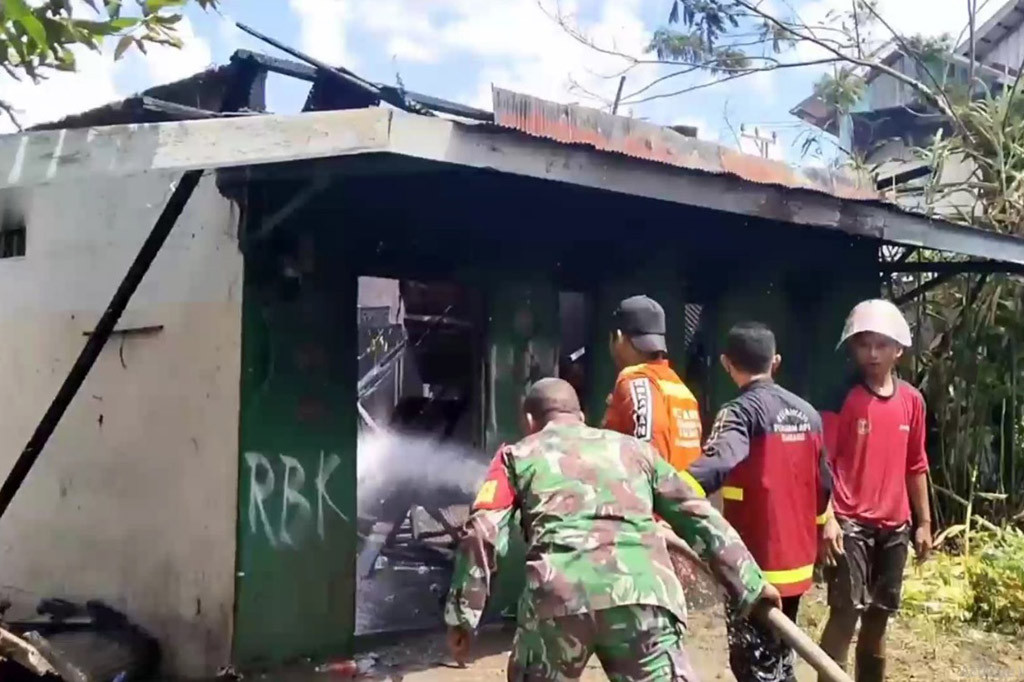 Petugas pemadam kebakaran bersama relawan, berupaya memadamkan api, agar tidak menjalar ke bangunan lain, sebab lokasi kebakaran berada di kawasan padat penduduk.