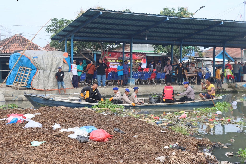 Polisi, TNI dan masyarakat pesisir gotong royong melakukan kerja bakti membersihkan sampah di Sungai Desa Penatarsewu Kecamatan Tanggulangin, Sidoarjo, Kamis, 13 Juli 2023.