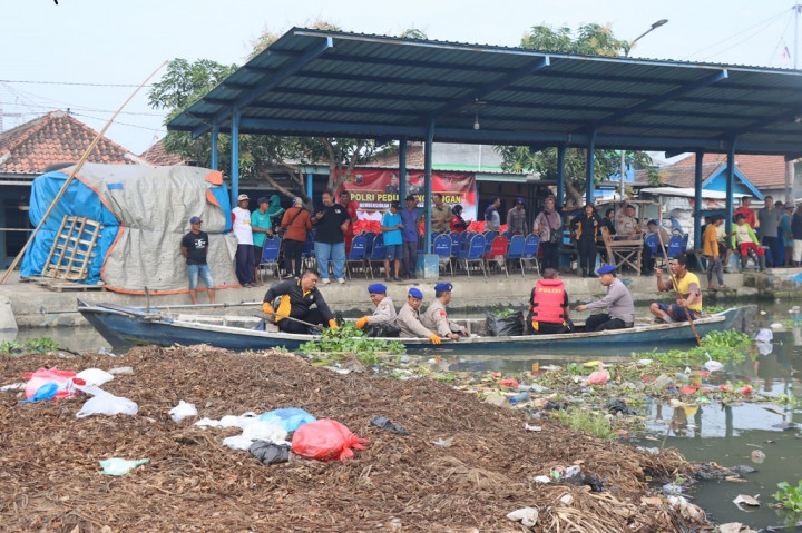 Polisi, TNI dan masyarakat pesisir gotong royong melakukan kerja bakti membersihkan sampah di Sungai Desa Penatarsewu Kecamatan Tanggulangin, Sidoarjo, Kamis, 13 Juli 2023.