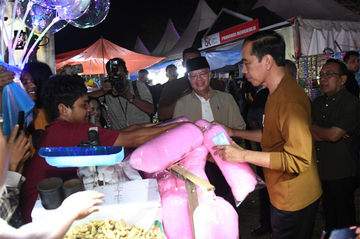 Sembari berkeliling menyapa warga, Presiden berhenti sejenak di sebuah lapak yang menjajakan gulali sebelum memutuskan membeli lima buah dagangan yang dijajakan.