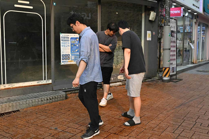 Video yang diposting di saluran YouTube stasiun televisi lokal YTN menunjukkan petugas tanggap darurat berjubah oranye berlari menuju lokasi kejadian sambil membawa tandu. ?