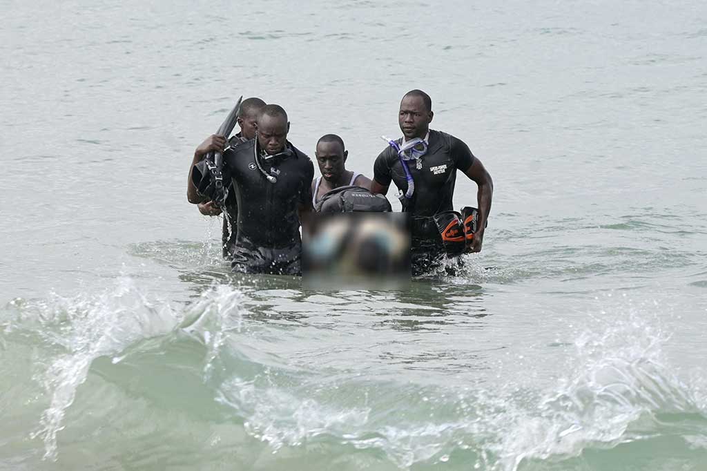 Petugas penyelamat mengevakuasi jenazah korban dari laut di Oukakam, setelah sebuah kapal terbalik di lepas pantai Dakar, Senegal, Senin, 24 Juli 2023. 