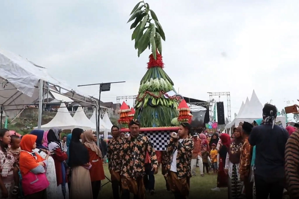 Tradisi grebeg apem dimulai dengan arak-arakan empat gunungan apem dan hasil bumi, mengelilingi Desa Mojosari, Bansari, Temanggung.