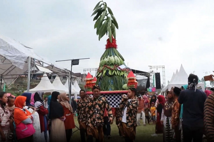 Tradisi grebeg apem dimulai dengan arak-arakan empat gunungan apem dan hasil bumi, mengelilingi Desa Mojosari, Bansari, Temanggung.