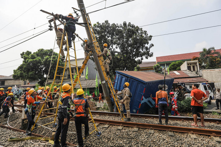 Petugas mengevakuasi truk yang menabrak tiang listrik aliran atas (LAA) hingga miring di jalur rel KRL antara Stasiun Pondok Ranji dan Kebayoran tapat di depan SMAN 86 Jakarta, Bintaro, Pesanggrahan, Jakarta Selatan, Selasa, 25 Juli 2023.