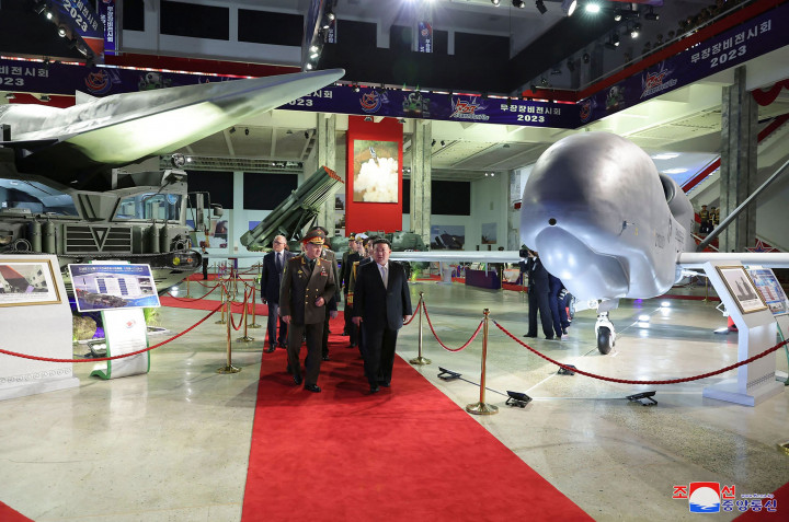 Kim berjalan bersama melintasi pameran pertahanan besar yang memamerkan rudal nuklir Korea Utara dan apa yang dikatakan oleh situs spesialis NK News yang berbasis di Seoul sebagai kendaraan udara tak berawak (UAV) baru.
