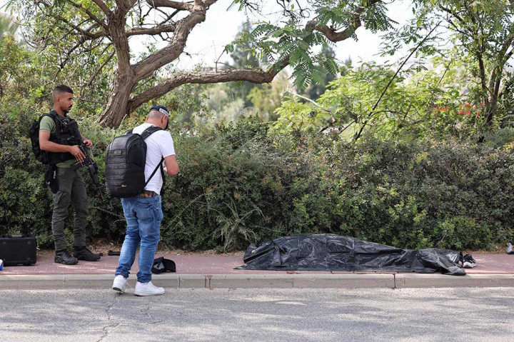 Anggota pasukan keamanan Israel berdiri di dekat jenazah tersangka penyerang di lokasi serangan di pemukiman Israel Maale Adumim di Tepi Barat yang diduduki, Selasa, 1 Agustus 2023.