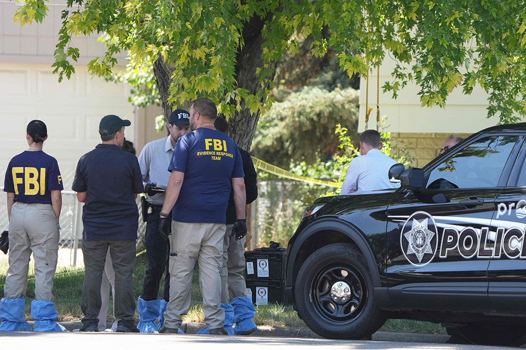 Pejabat FBI dan petugas penegak hukum lainnya berdiri di luar rumah Craig Robertson yang ditembak mati oleh FBI dalam penggerebekan di rumahnya di Provo, Utah, pada Rabu, 9 Agustus 2023.