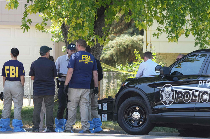 Pejabat FBI dan petugas penegak hukum lainnya berdiri di luar rumah Craig Robertson yang ditembak mati oleh FBI dalam penggerebekan di rumahnya di Provo, Utah, pada Rabu, 9 Agustus 2023.