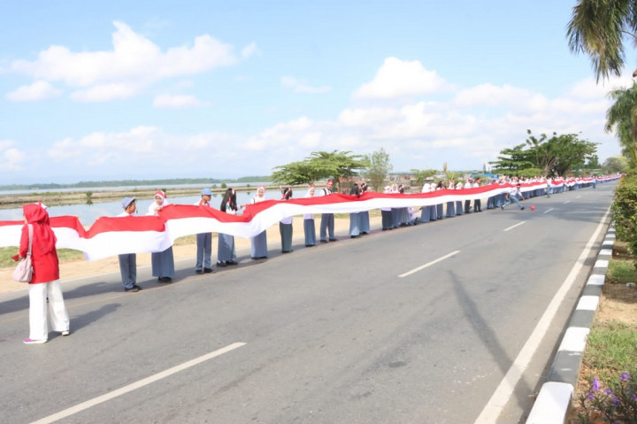 Ali mengatakan, sebanyak 17 ribu siswa-siswi SMA sambung menyambung membentangkan bendera merah putih dengan panjang 17 kilo meter yang melewati jalan protokol by pass pada dua daerah.