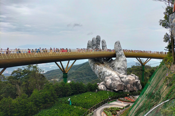 Daya tarik dari Ba Na Hills adalah Golden Bridge. Anda akan menyusuri jembatan yang seolah-olah ditopang oleh tangan raksasa. Selain itu, pengunjung bisa menikmati berbagai wahana menarik di Fantasy Park.