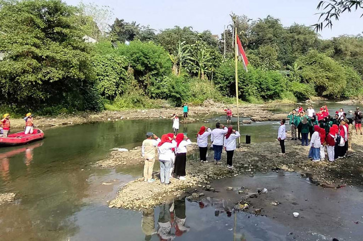 Warga RW 07 melakukan pengibaran bendera Mera Putih pada aliran Sungai Ciliwung yang mulai mengering akibat kemarau panjang di Kedung Halang, Kota Bogor, Jawa Barat, Kamis, 17 Agustus 2023. Dalam kegiatan itu warga juga melakukan aksi bersih-bersih sampah di aliran sungai.