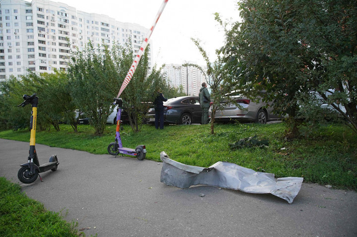 Penduduk setempat berdiri di samping puing-puing pesawat tak berawak (drone) yang ditembak jatuh di Krasnogorsk, wilayah Moskow pada Selasa, 22 Agustus 2023.