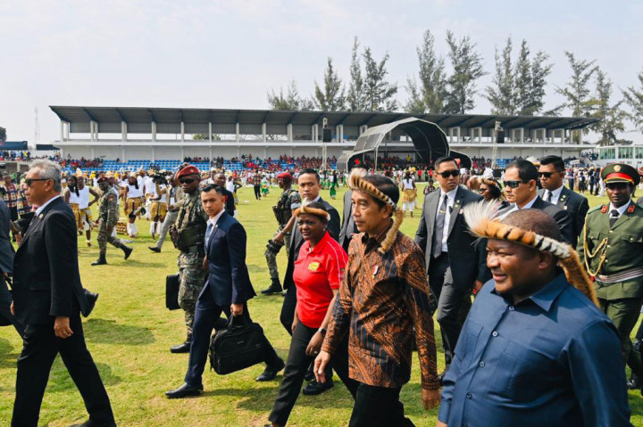 Kedua pemimpin negara pun kemudian berjalan bersama-sama menuju panggung kehormatan. Presiden Jokowi bersama Presiden Nyusi pun terlihat kompak mengenakan ikat kepala tradisional Afrika.