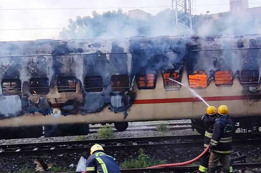 Petugas berusaha memadamkan api yang melalap sebuah gerbongkereta yang diparkir di India selatan terbakar, Sabtu, 26 Agustus 2023. Sembilan orang tewas akibat kebakaran tersebut. Kebakaran terjadi ketika seorang penumpang mencoba membuat teh.