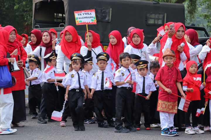 Juga ada beragam hiasan kepala yang dikenakan anak-anak TK tersebut. Di jemari imutnya, mereka memegang bendera merah putih. Mereka didampingi orang tua dan para guru.