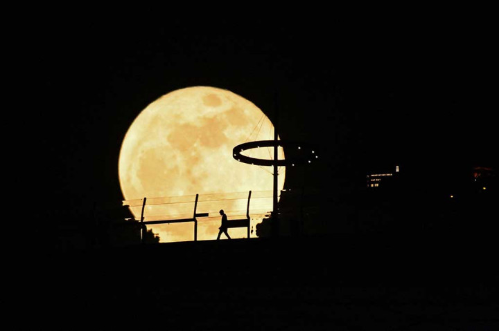 Super Blue Moon muncul di belakang dek observasi Marina Bay Sands, Singapura, Kamis, 31 Agustus 2023. AFP PHOTO/Roslan Rahman