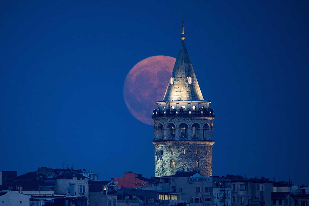 Super Blue Moon, bulan purnama kedua dalam satu bulan kalender, muncul di belakang menara Galata di Istanbul, Turki, Rabu, 30 Agustus 2023. AFP PHOTO/ Yasin Akgul