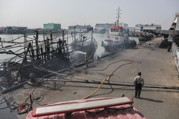 Petugas Suku Dinas Penanggulangan Kebakaran dan Penyelamatan Jakarta Utara melakukan pendinginan sembilan kapal nelayan yang terbakar di dermaga barat Pelabuhan Perikanan Samudera Nizam Zachman Muara Baru, Jakarta Utara, Selasa, 5 September 2023.