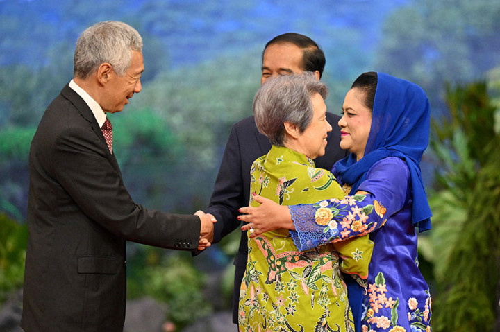 Memakai setelan jas lengkap berwarna hitam dan dasi merah, dan didampingi Ibu Iriana yang mengenakan kebaya encim biru berhiaskan bordir bunga-bunga dan kain bawahan batik berwarna senada, Presiden Jokowi menyalami para pemimpin ASEAN.