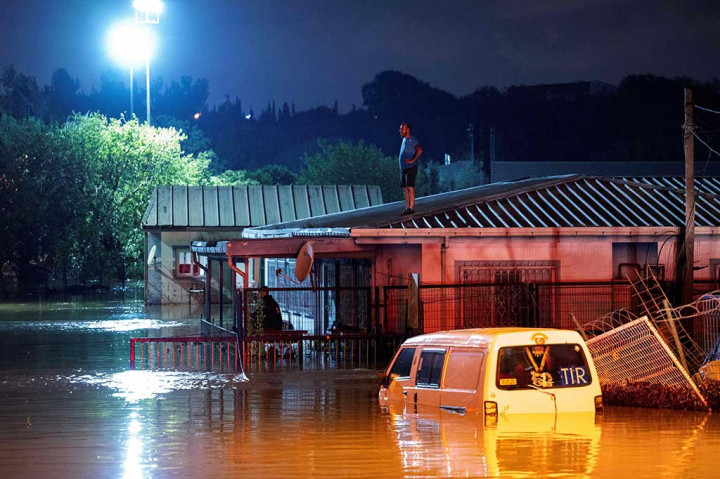 Tayangan di televisi dan media sosial menunjukkan derasnya air menyapu mobil dan kios pasar kota.