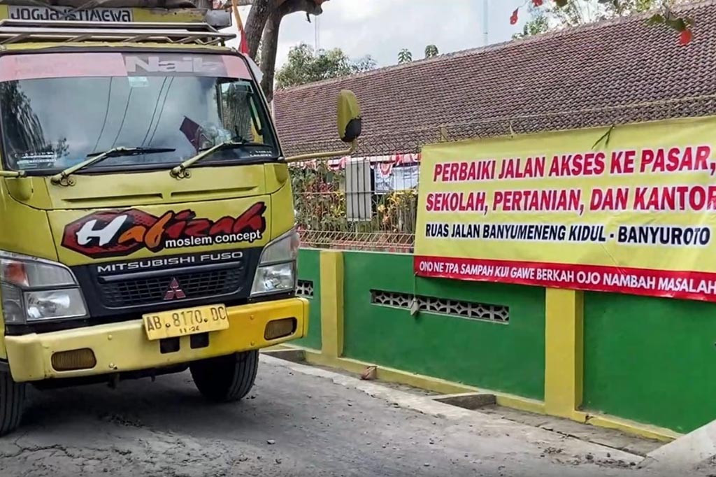 Debu yang berterbangan dari jalan yang berada di depan sekokah mengganggu siswa dan guru. Kondisi debu makin parah saat kendaraan roda empat atau truk melintasi jalan ini.