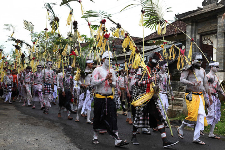 Warga berkeliling kampung dengan memakai riasan warna-warni saat ritual Ngerebeg di Desa Tegallalang, Gianyar, Bali, Rabu, 6 September 2023. 