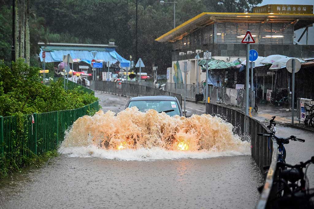 Seorang pengendara mobil nekat menerjang banjir di Pulau Lantau, Hong Kong, Jumat, 8 September 2023.