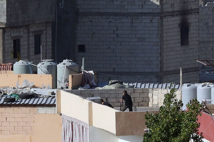 Para pejuang mengambil posisi di atap sebuah gedung di kamp Ain al-Helweh untuk pengungsi Palestina di pinggiran kota Sidon di Lebanon selatan pada Rabu, 13 September 2023, selama pertempuran baru antara anggota gerakan Fatah dan militan Islam garis keras. 