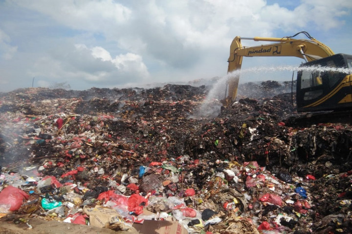 Tim menurut mikron masih terus berupaya melakukan pemadaman dengan menyemprot air ke tumpukan sampah yang di bongkar alat beras.