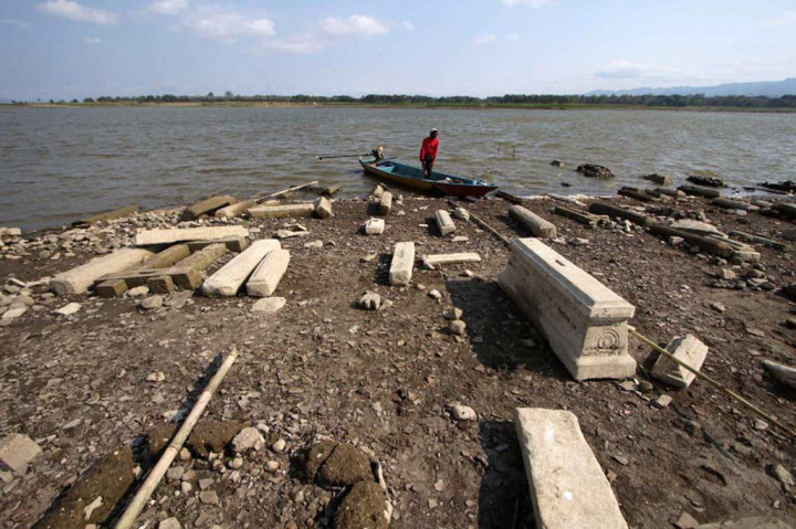 Warga turun dari perahu di area permakaman lama di dasar Waduk Gajah Mungkur yang mengering di Wonogiri, Jawa Tengah, kemarin.