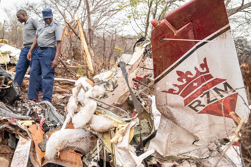 Petugas polisi memeriksa puing-puing pesawat yang jatuh di sebuah desa di dekat Masvingo, Zimbabwe, Jumat, 29 September 2023 waktu setempat. Kecelakaan tersebut menewaskan enam orang, termasuk sang pilot.